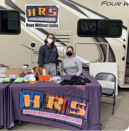 Volunteers at an event table for Harm Reduction Services