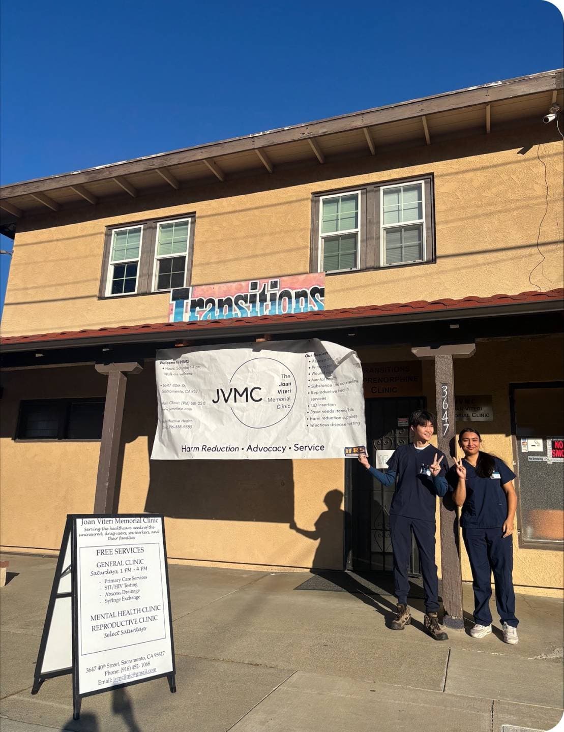 Two members in front of poster